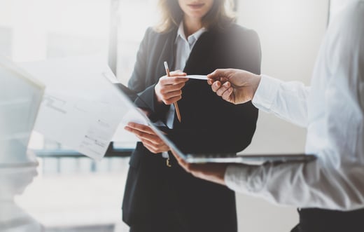 Ansprechpartner - Berater übergibt Visitenkarte für weiteren Kontakt.