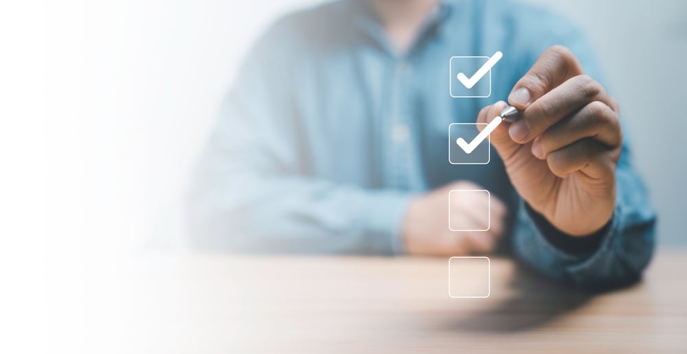 Geschäftsmann markiert mit einem Kuli ein Kontrollkästchen zur Qualitätskontrolle von Dokumenten – Bestätigung eines Projektkonzepts mit Vorteilen auf einen Blick für Finanzierung und Risikominimierung